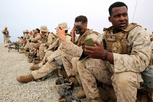 Marines with 3rd Battalion, 5th Marine Regiment, 1st Marine Division, apply camouflage paint before conducting a helicopter raid, as part of the Marine Corps Combat Readiness Evaluation (MCCRE), aboard Marine Corps Base Camp Pendleton, Calif., Aug. 4, 2015. The MCCRE is used evaluate the operational readiness of a designated unit. (U.S. Marine Corps Photo by Cpl. Demetrius Morgan/RELEASED)
